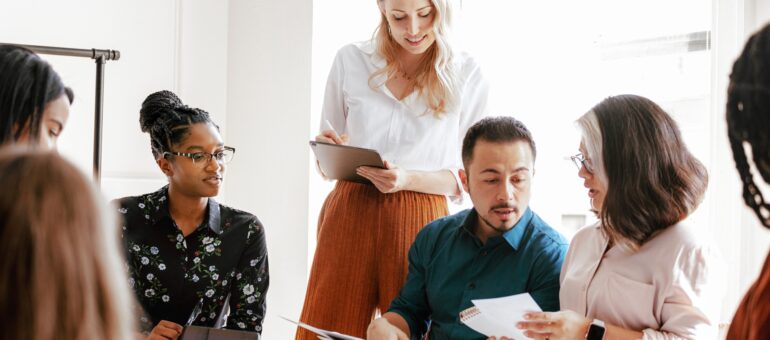 Diverse team in a meeting. A diverse team in a business meeting. The team discusses and brainstorm. The diverse business team collaborates in a bright office. Diverse group of people in meeting room
